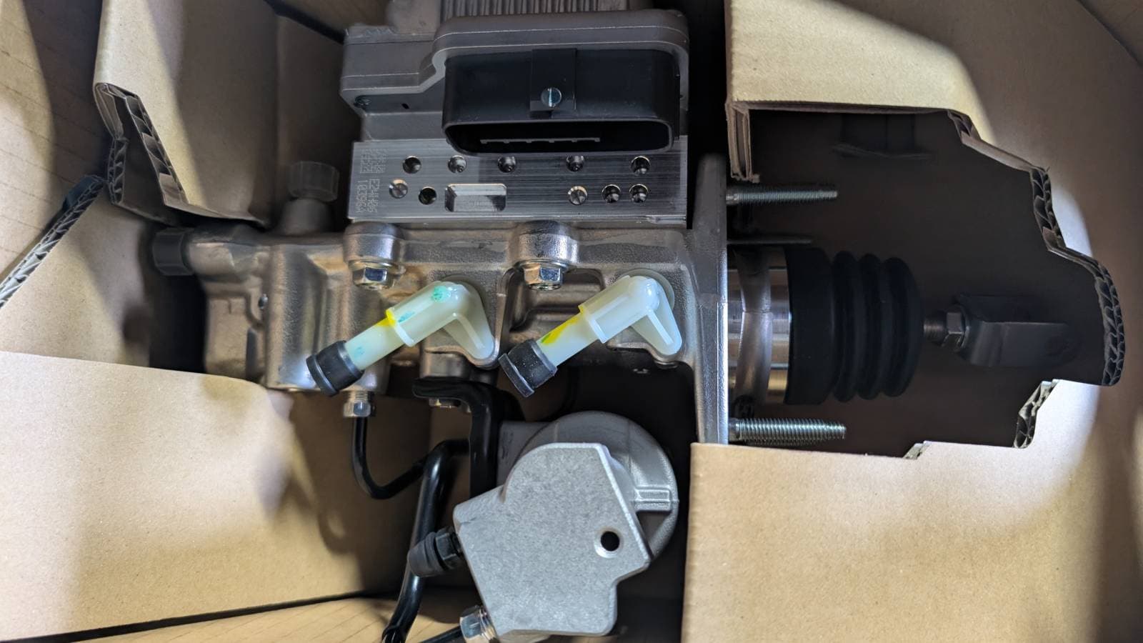 New OEM ABS actuator and master cylinder unboxed on shop bench